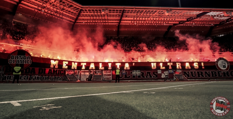 Symbolbild Symbolfoto Feature Impression - Choreografie der Zuschauer / Publikum / Fans / Ultras / Banda di Amici des FCN vor Spielbeginn - Mentalita Ultras! - Pyrotechnik / Pyro / Bengalfackel / Bengalfackeln / Rauch